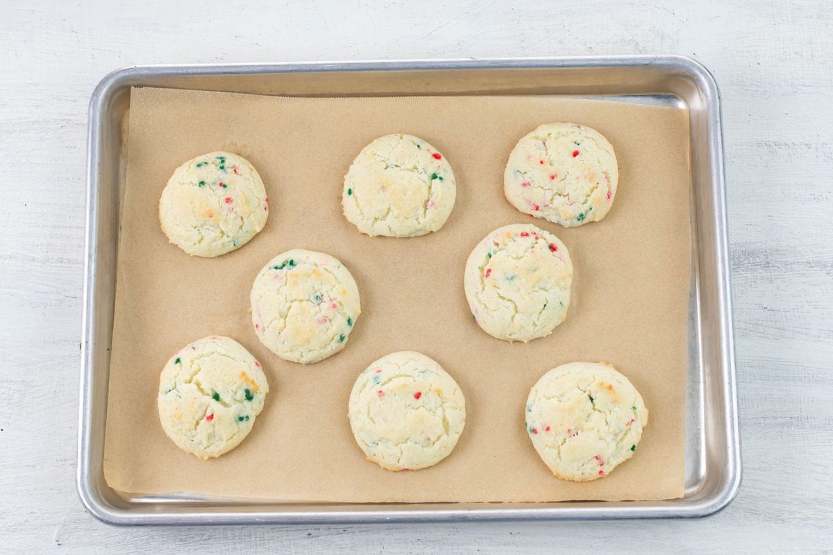 Baked Funfetti Christmas cookies cooling on the baking sheet.