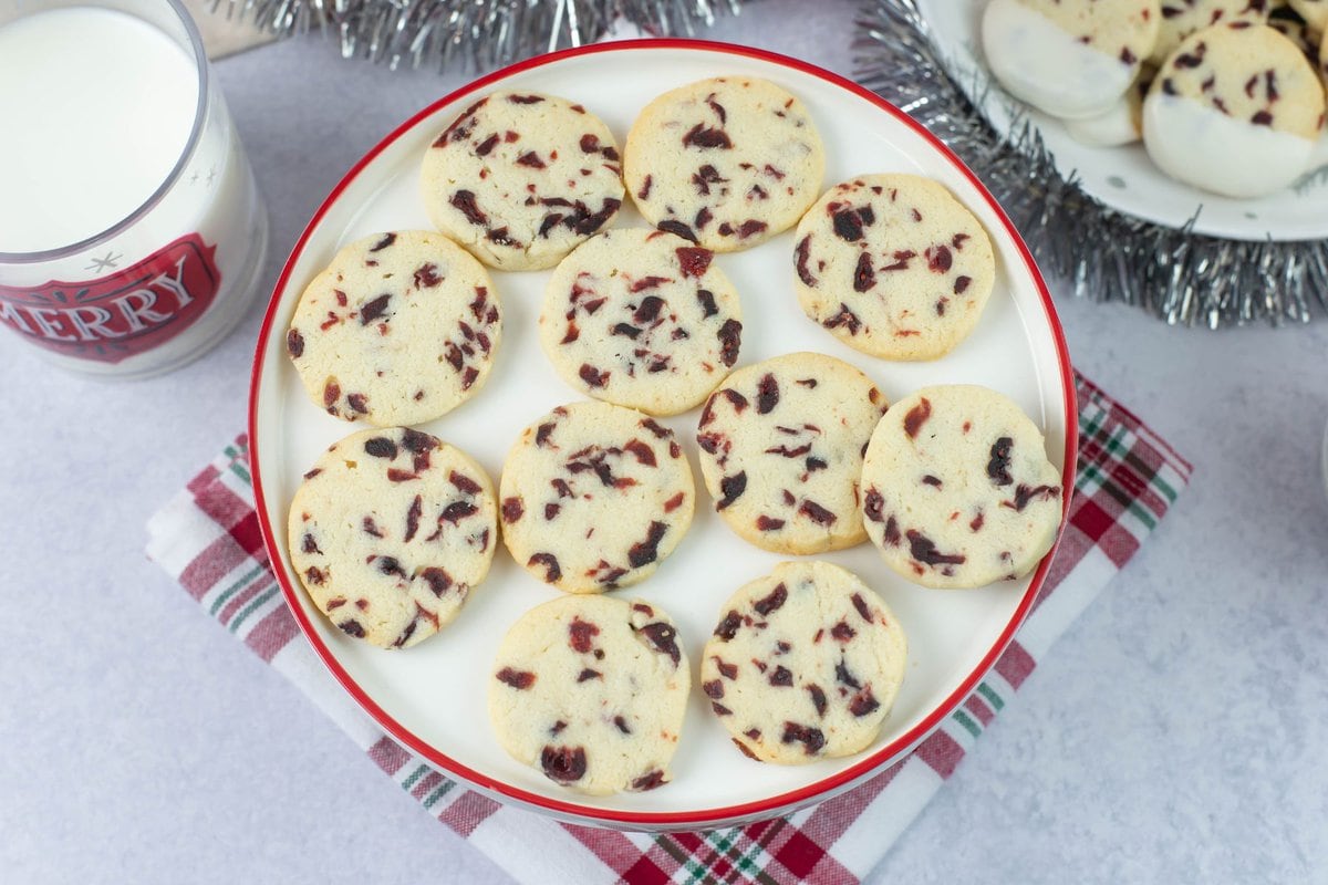 Cranberry shortbread cookies on a white cake stand.