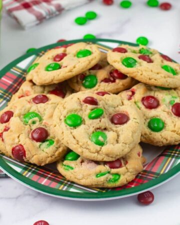 M & M Christmas Cookies stacked on a holiday plate.