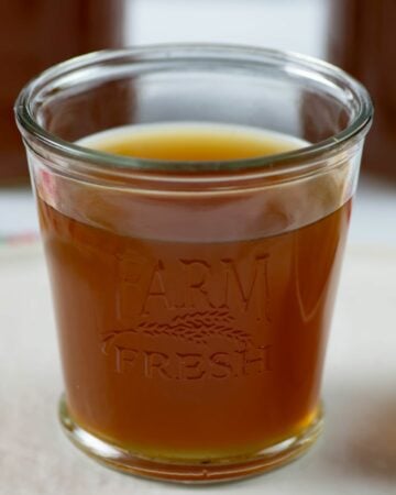 Instant Pot Beef Bone Broth in a glass on a table.