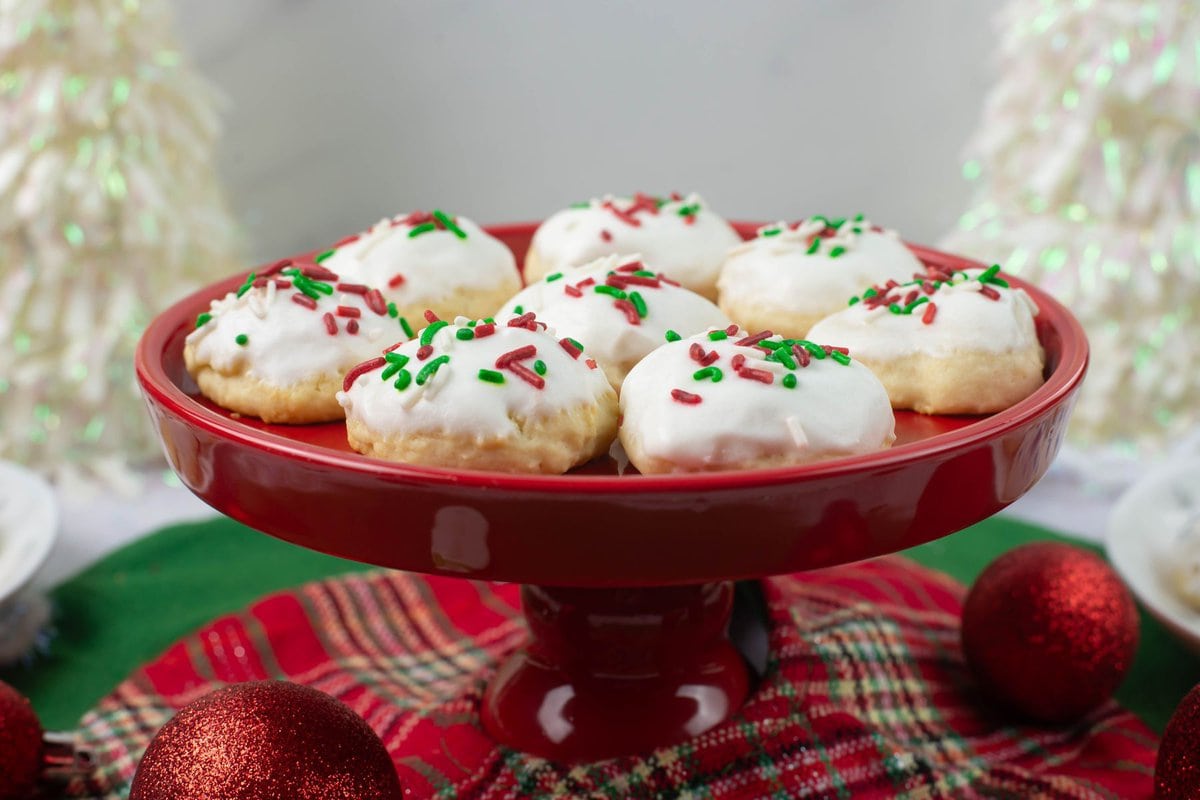 Italian Riccota Christmas cookies served on a red cake stand.