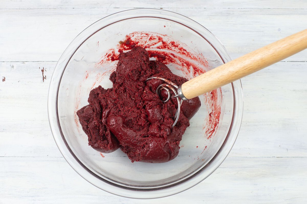 Red velvet cookie dough in a bowl before adding white chocolate.