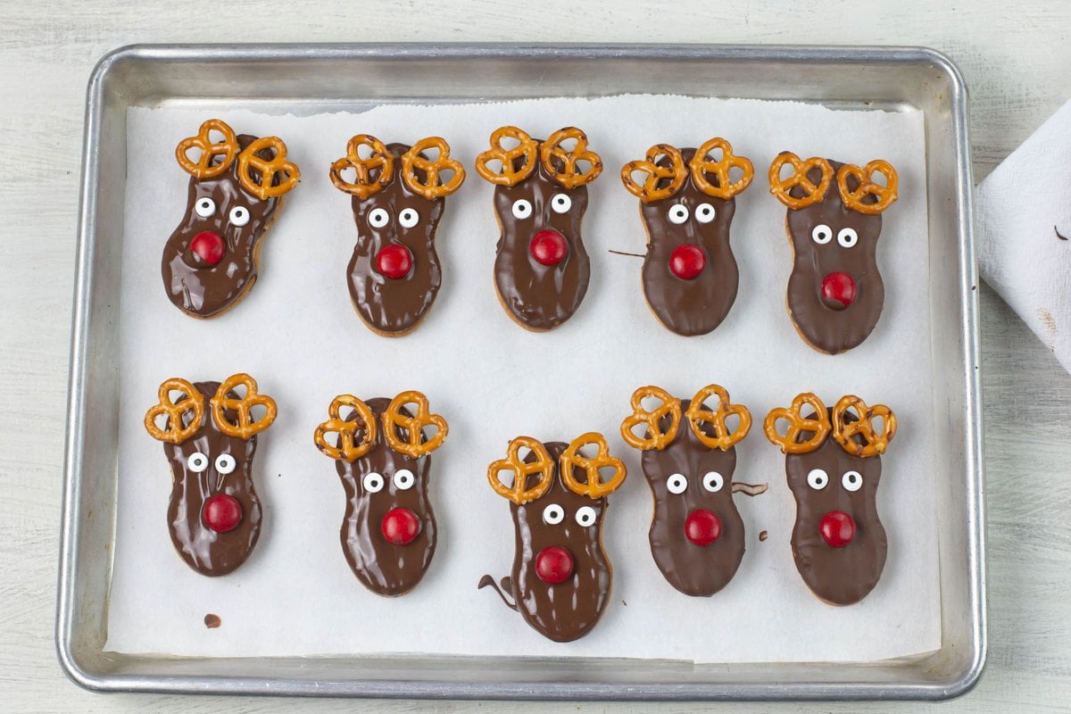 Rudolph the reindeer nutter butter cookies dipped in chocolate on a baking tray.