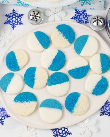 Blue and white Christmas Cookies on a glass plate.