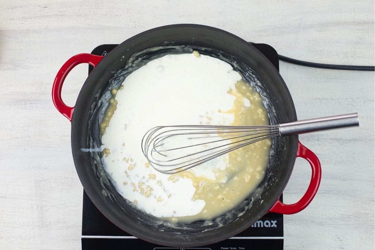 Adding cream to a roux in a hot skillet.