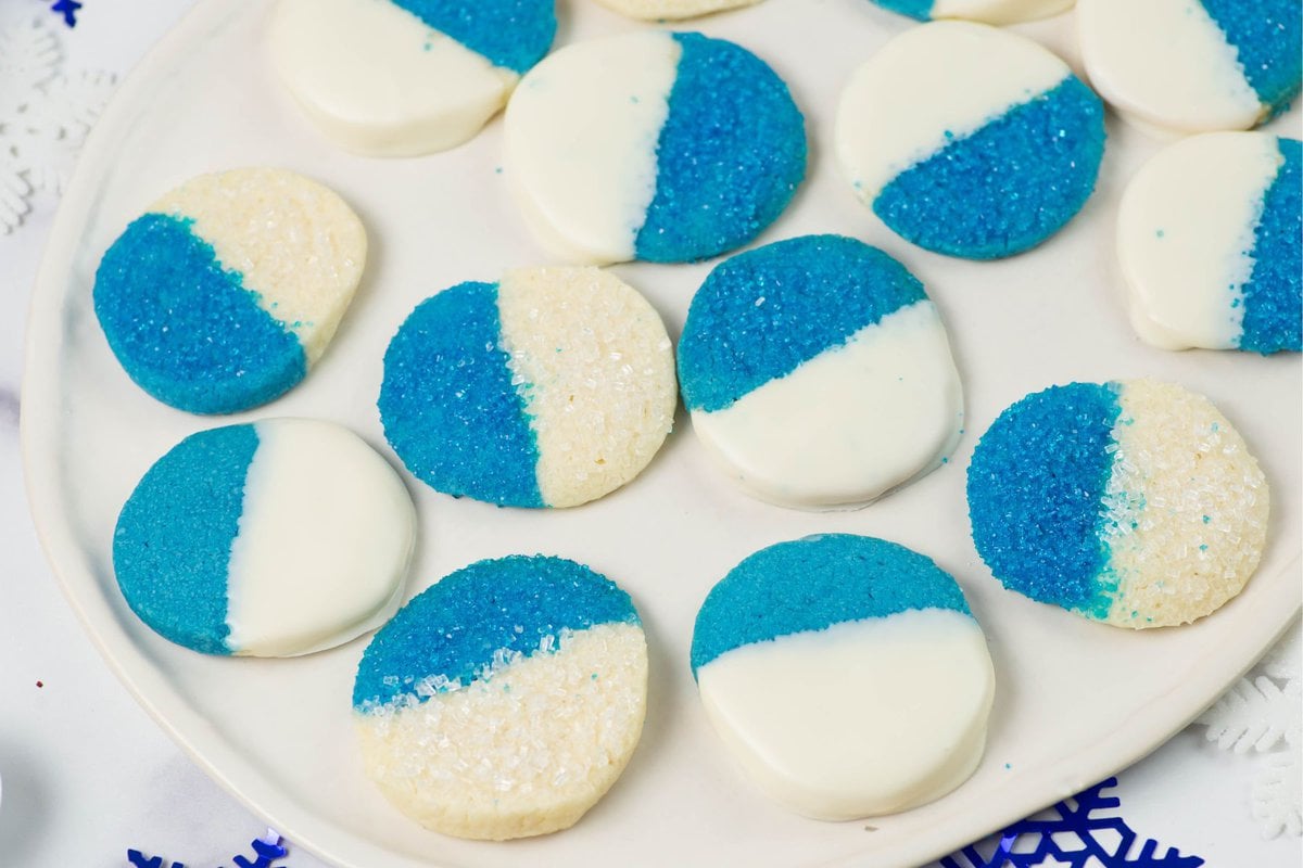 Dipped and decorated blue and white cookies on a platter.
