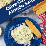 Serving of Olive Garden Alfredo Sauce with fettuccine pasta on a dinner plate.