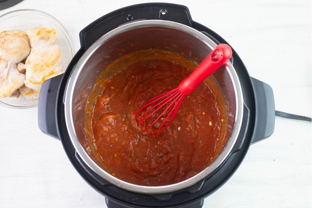 Mixing marinara sauce with seasoning.