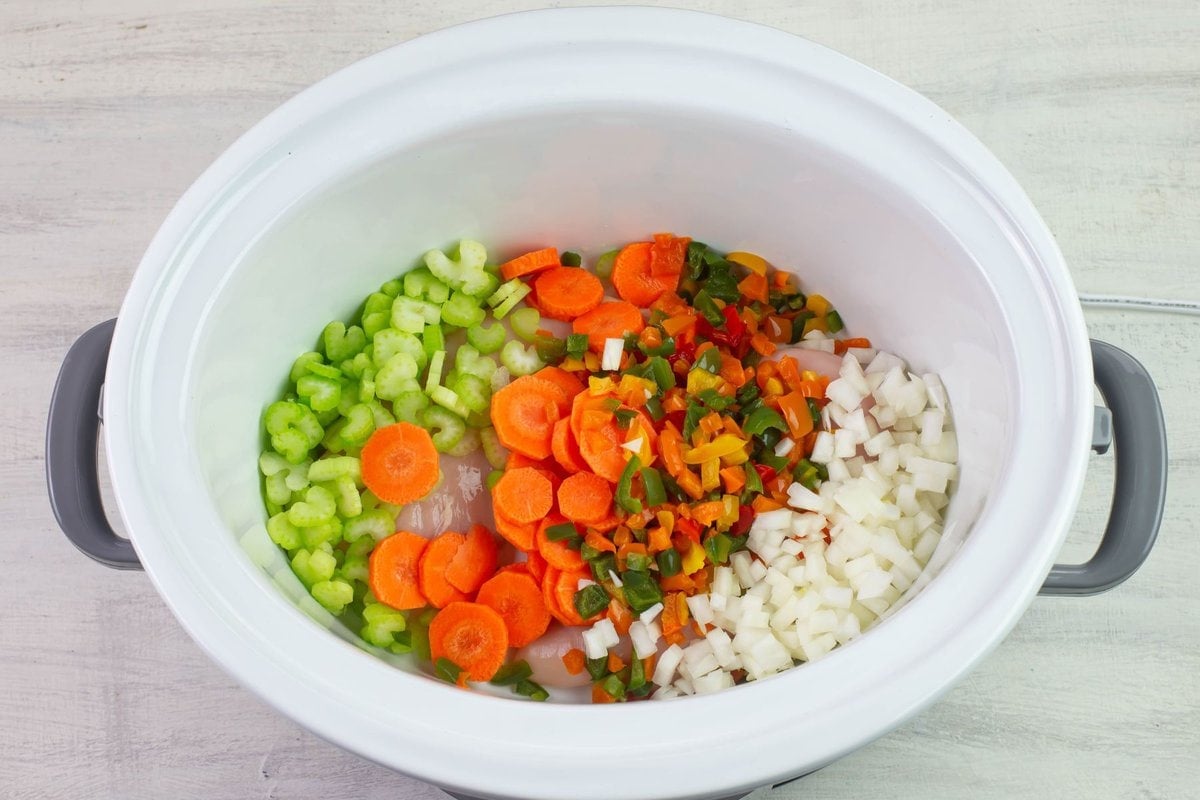 Mixing the chicken and vegetables in the crock pot.
