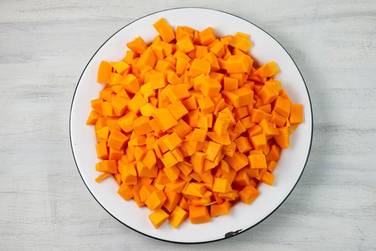 Cubed and blanched butternut squash in a large enamel bowl.