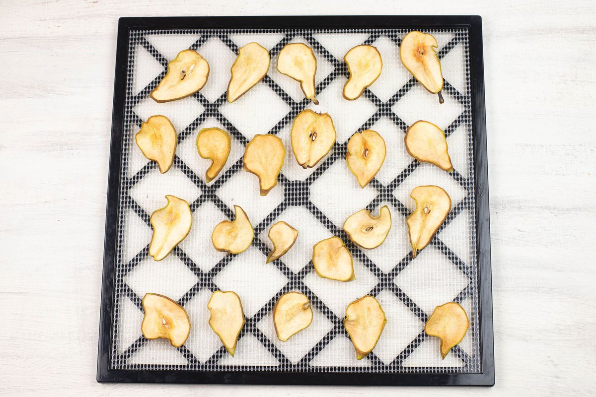 Dried pear slices on a dehydrator tray.