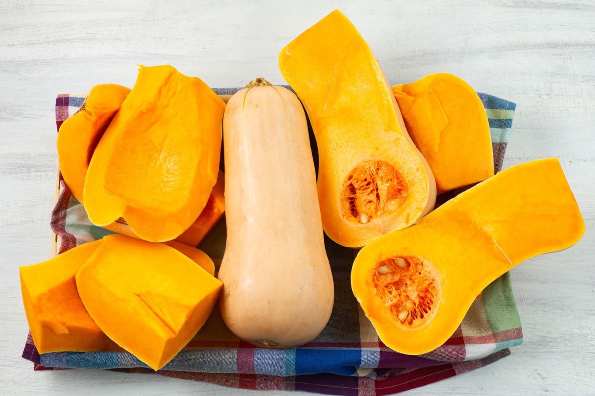 Fresh butternut squash cut into pieces with the seeds removed.