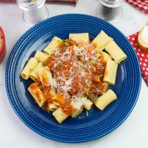 Instant Pot Chicken Marinara served over rigatoni pasta on a dinner plate.