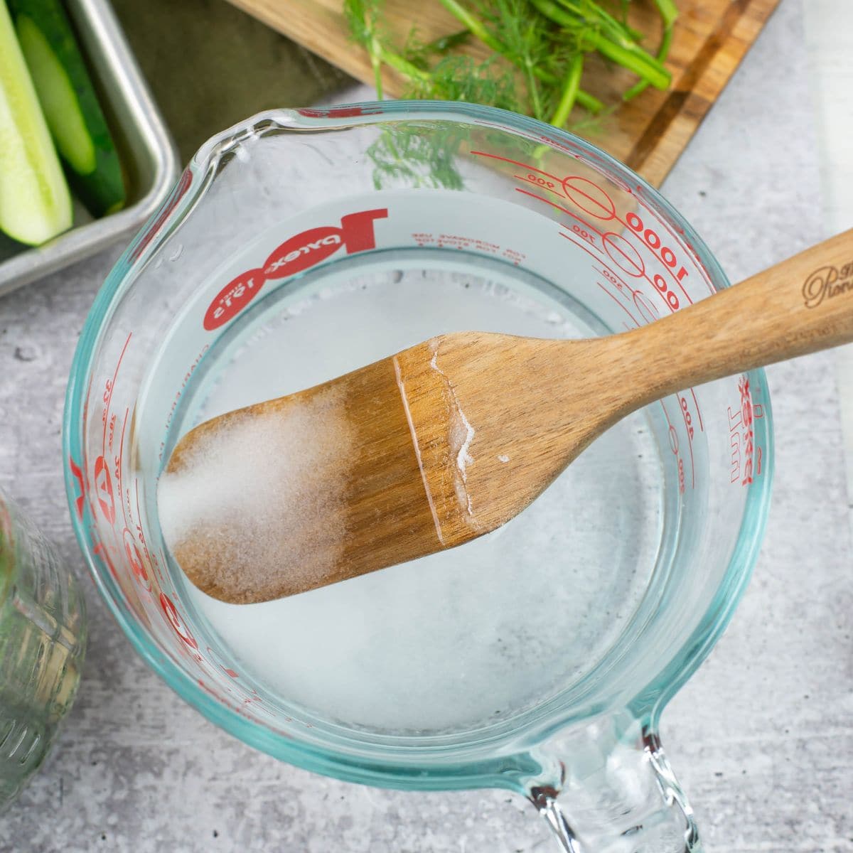 Mixing water and pickling salt in a large spouted measuring cup.