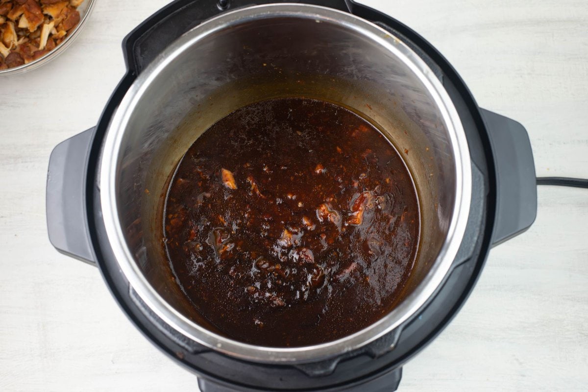 Thickening the hoisin sauce with cornstarch and water inside the pot.
