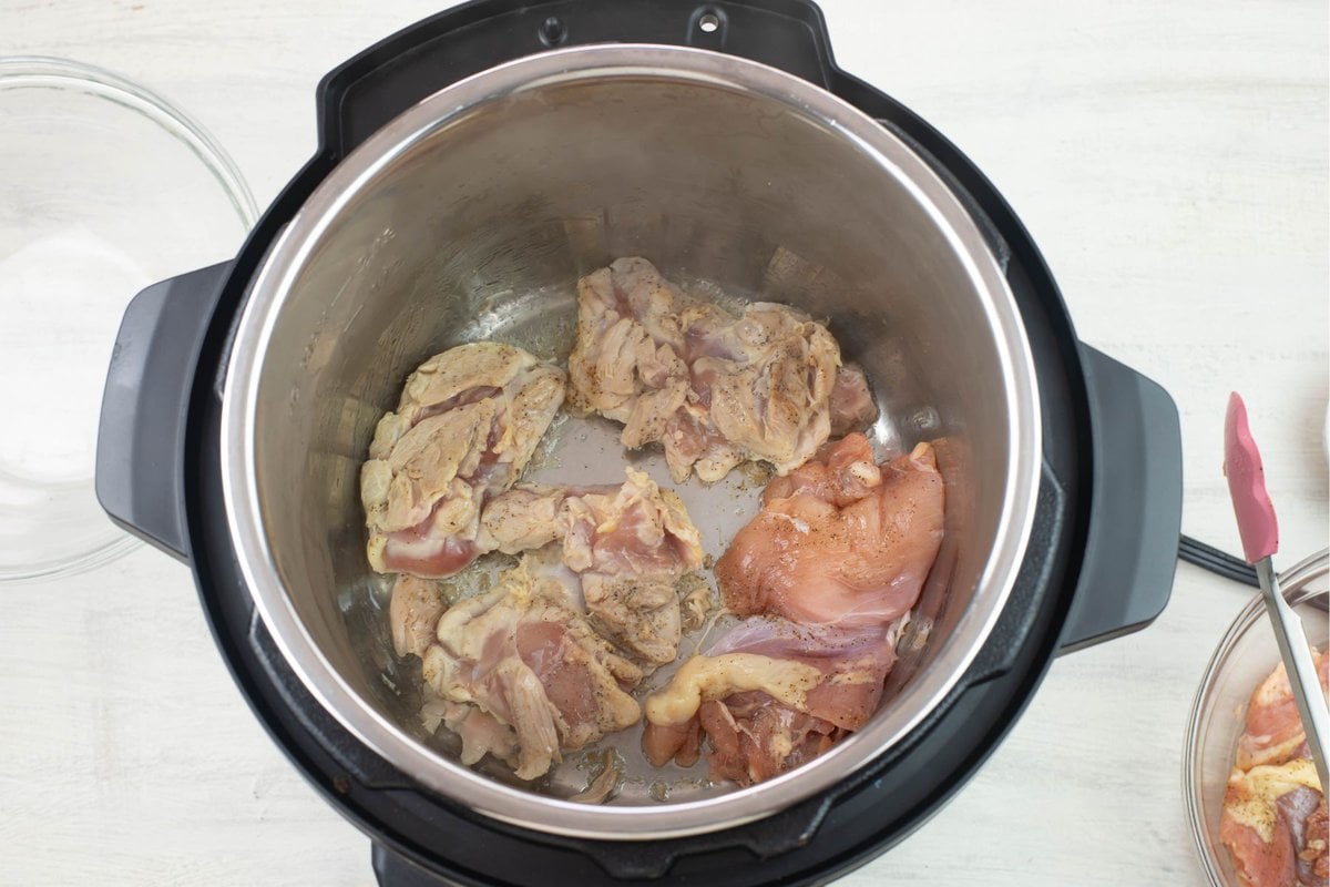 Browning seasoned chicken thighs in the Instant Pot.