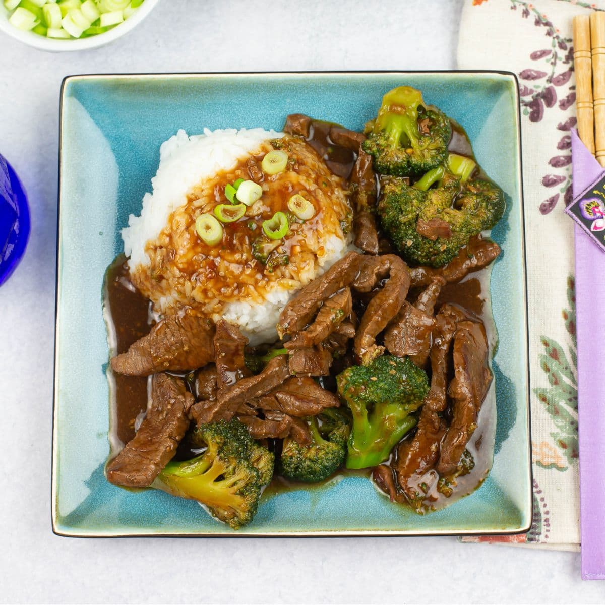 Instant Pot Beef and Broccoli served with white rice and garnished with green onions.