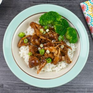 Single serving of Instant Pot Chicken Adobo over rice with steamed broccoli.