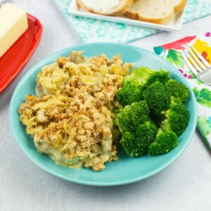 Chicken and Stuffing served with steamed broccoli in a shallow bowl.