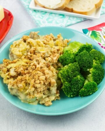 Chicken and Stuffing served with steamed broccoli in a shallow bowl.