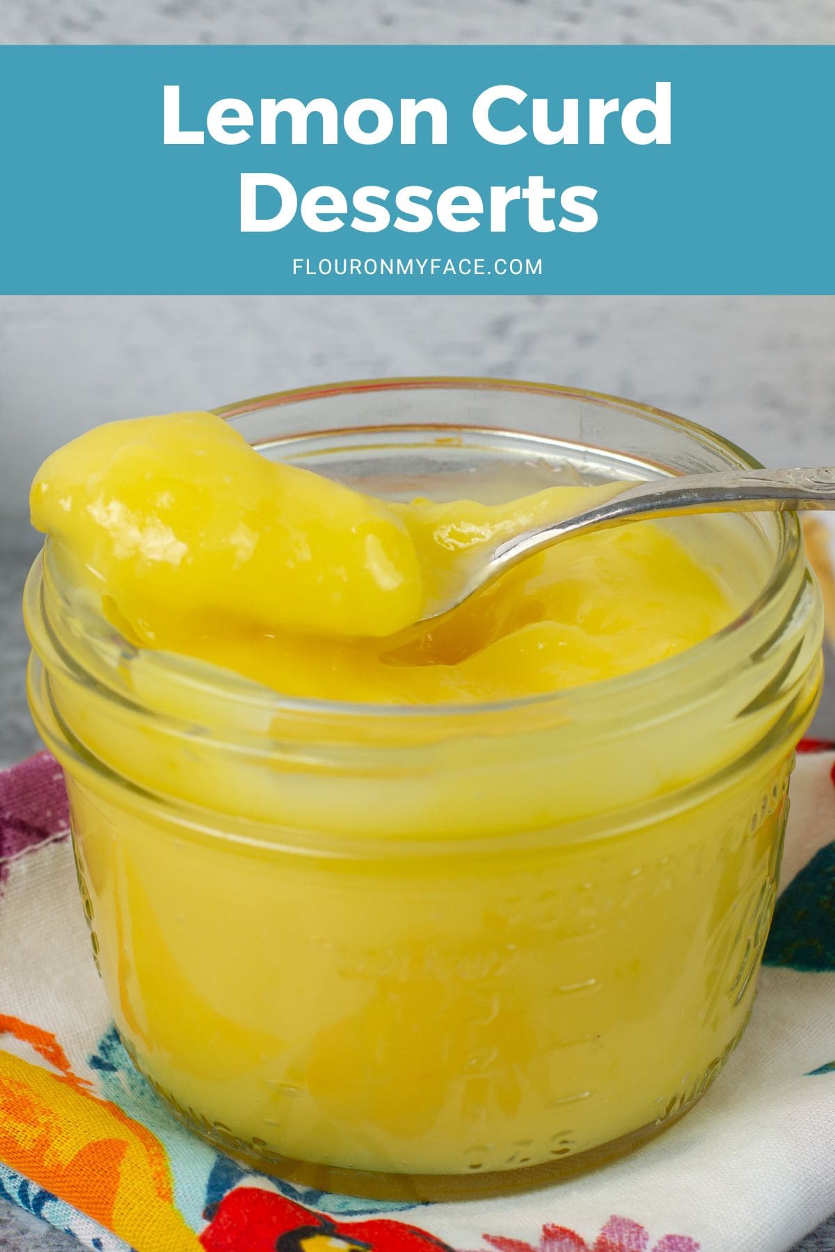 Closeup of a jar of homemade lemon curd, spoon resting on the lip.
