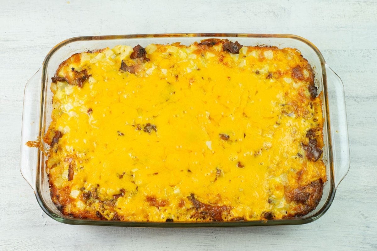 A baked cheesy breakfast casserole before cutting.