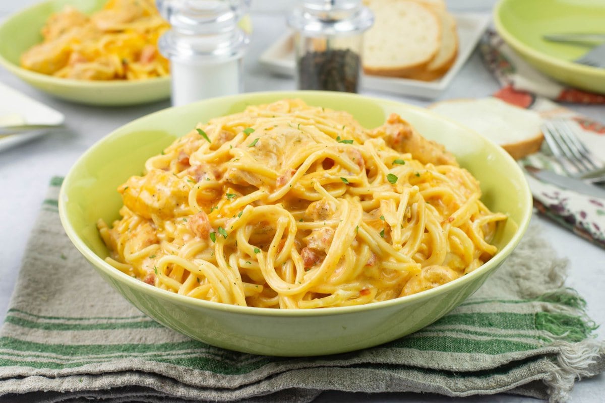 Single serving of cheesy chicken spaghetti in a green bowl.
