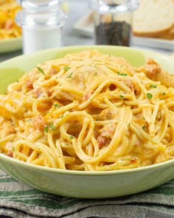 Single serving of cheesy chicken spaghetti in a green bowl.