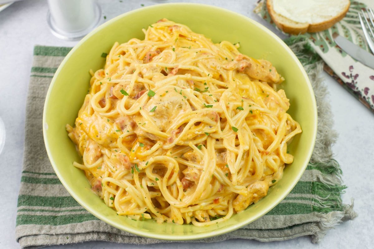 Green serving bowl filled with Chicken Spaghetti made with Rotel.