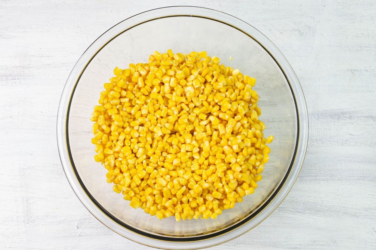 A bowl filled with thawed frozen corn kernels.