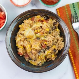 Mexican chicken and rice served in a bowl and topped with salsa.