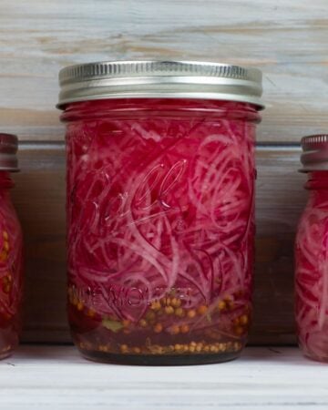 Mason jar filled with quick pickled red onions.