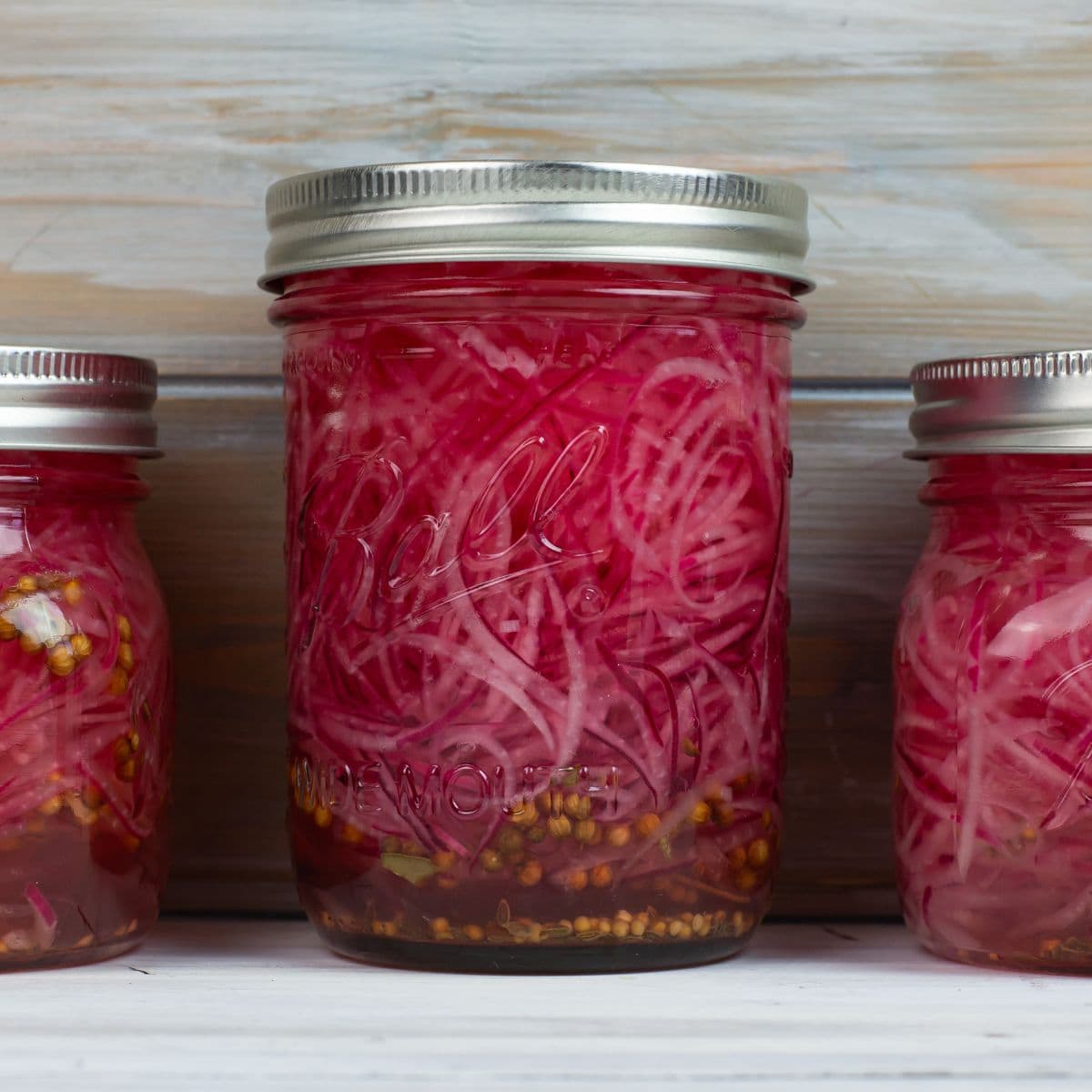 Mason jar filled with quick pickled red onions.