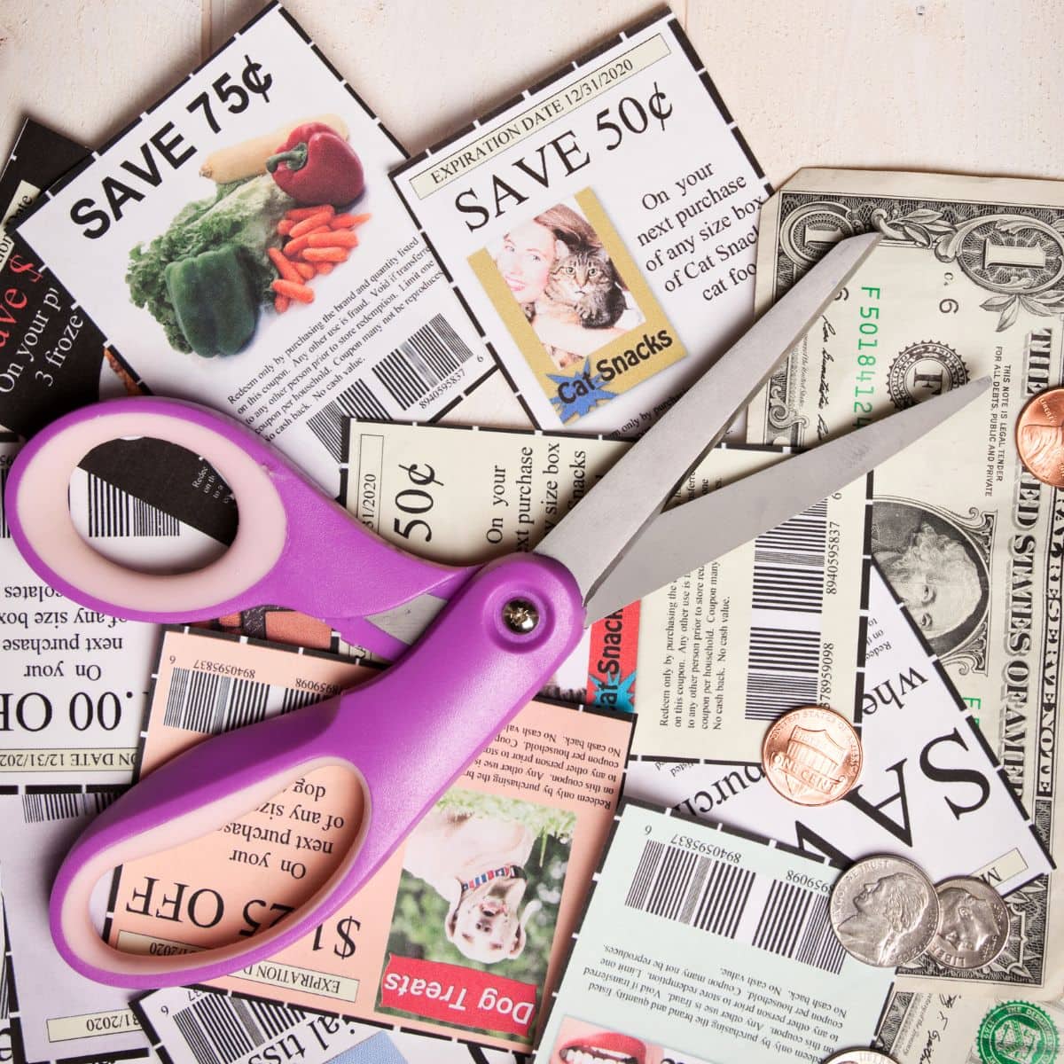 Cut out paper coupons with a scissor on a table.