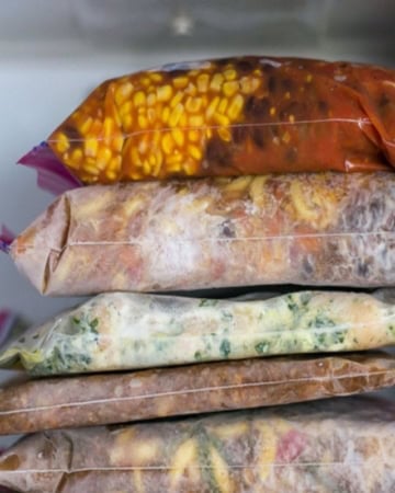 5 frozen freezer meals in bags inside a freezer.
