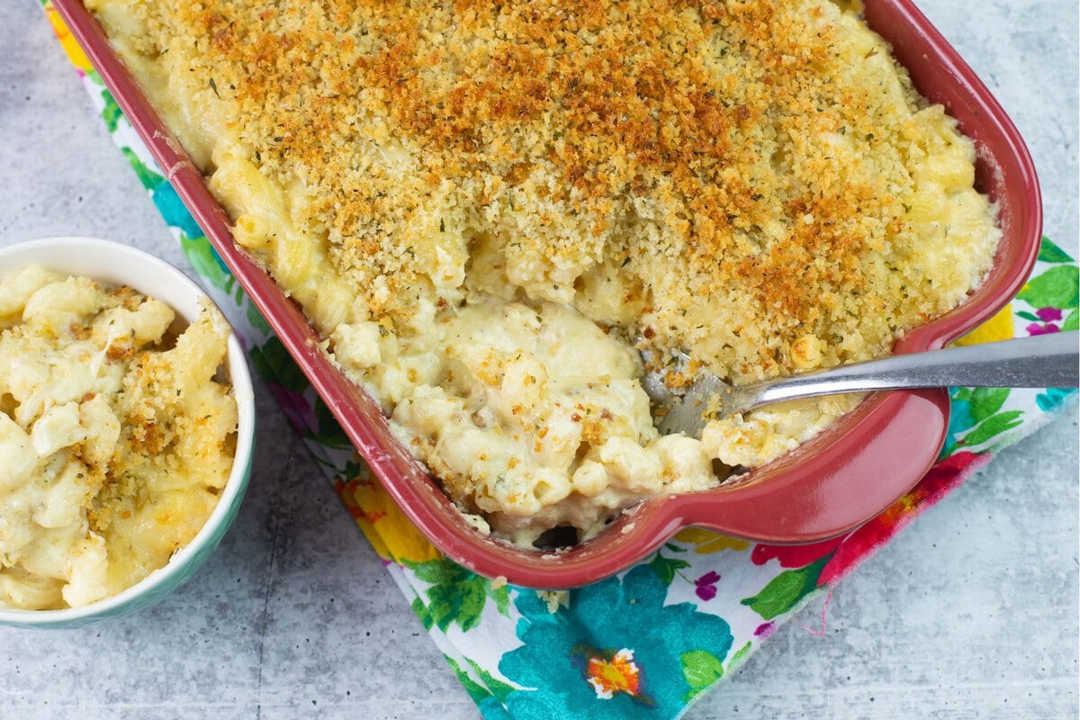 Baked mac and cheese in  casserole dish with serving removed.