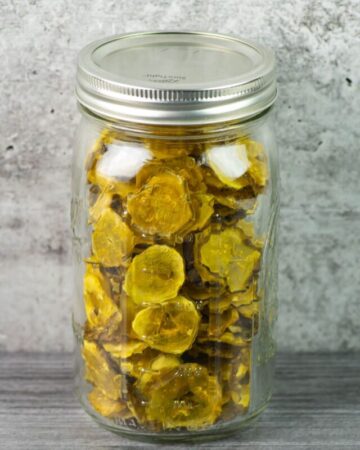 Dehydrated pickle chips in a large mason jar.