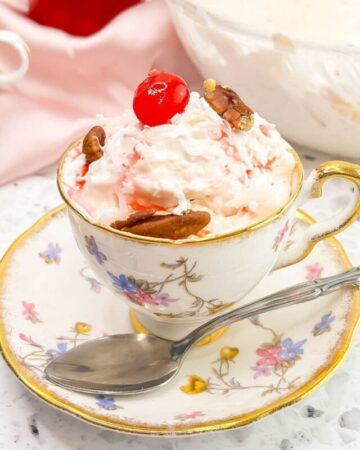 Million Dollar Fruit Salad served in a fancy tea cup.