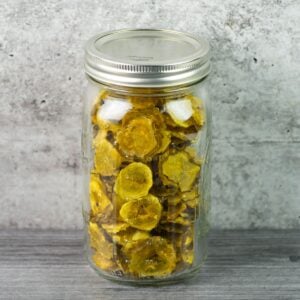 Dehydrated pickle chips in a large mason jar.