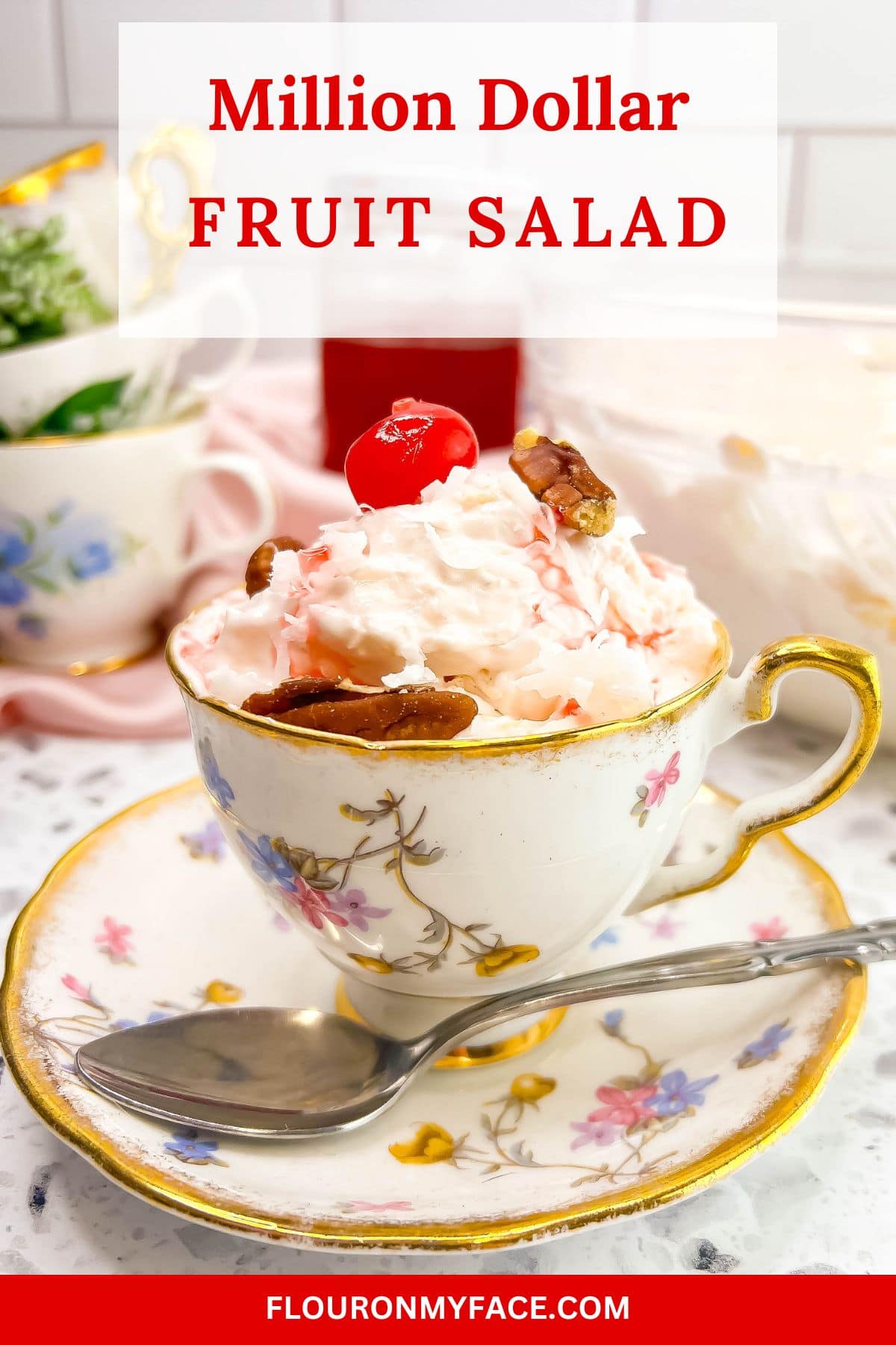 Large vertical closeup image of a serving of Million Dollar Fruit Salad recipe served in a vintage tea cup.