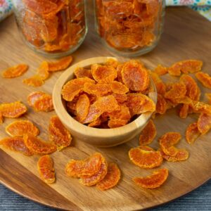 Dehydrated Mandarin orange slices in a small wooden bowl.