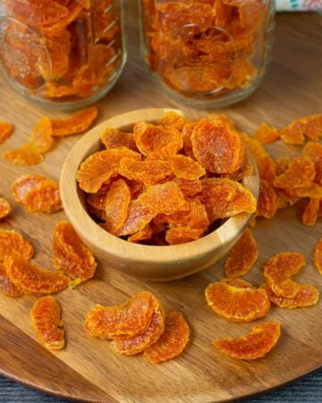 Dehydrated Mandarin orange slices in a small wooden bowl.