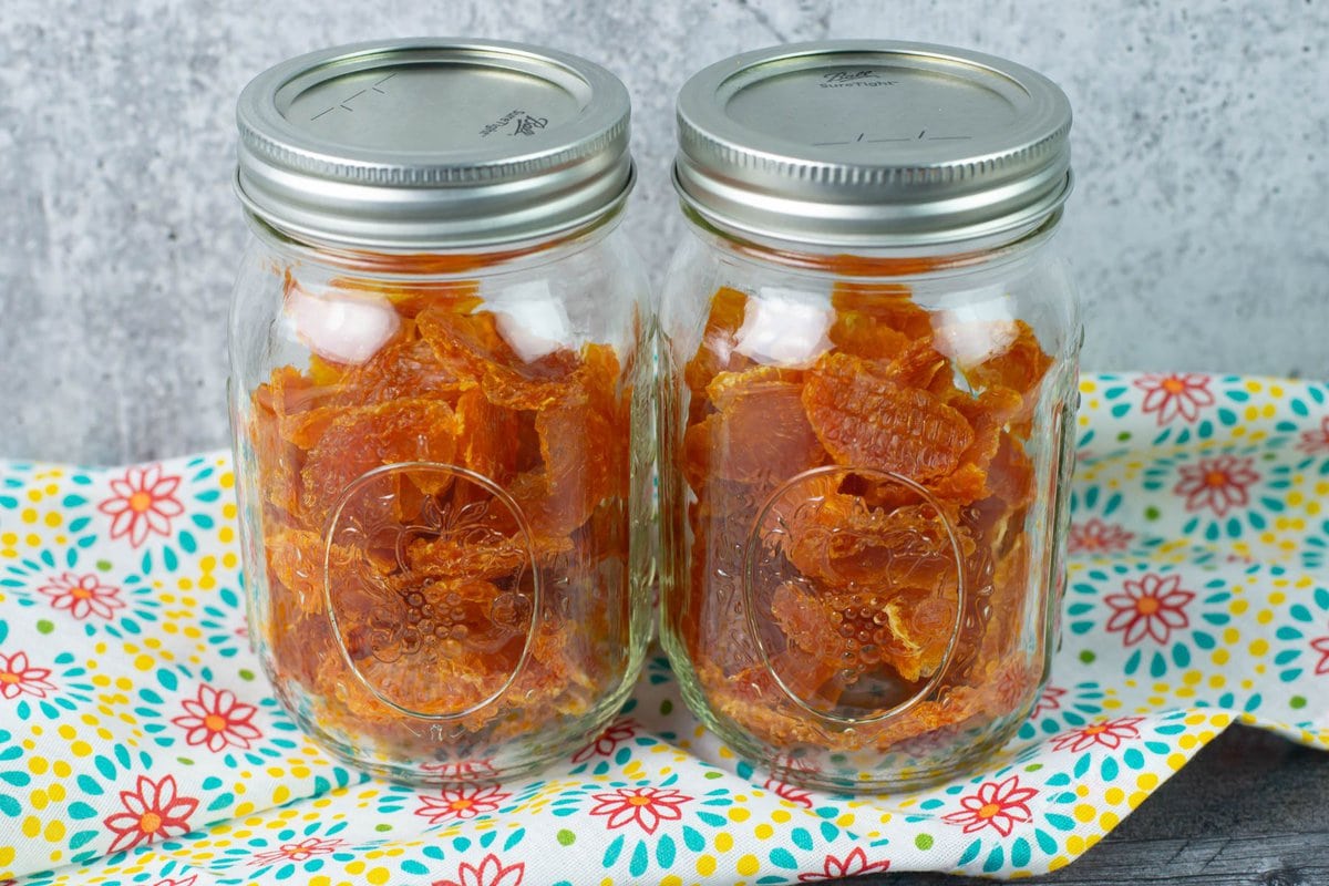 Two jars of dried fruit on a cloth napkin.