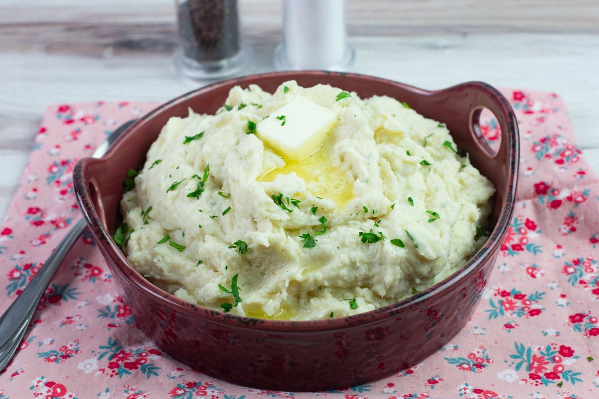 Serving bowl on a napkin filled with mashed potatoes.