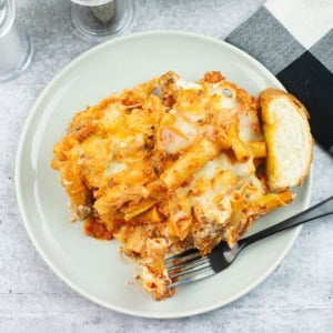 A serving of Million Dollar Baked Ziti made in a slow cooker on a dinner plate.