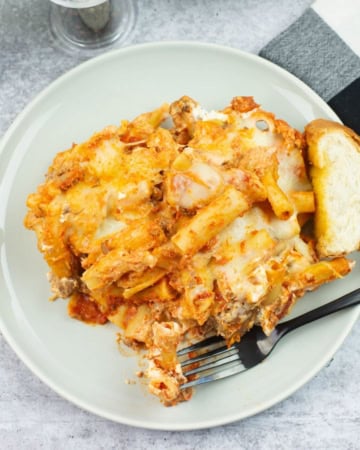 A serving of Million Dollar Baked Ziti made in a slow cooker on a dinner plate.