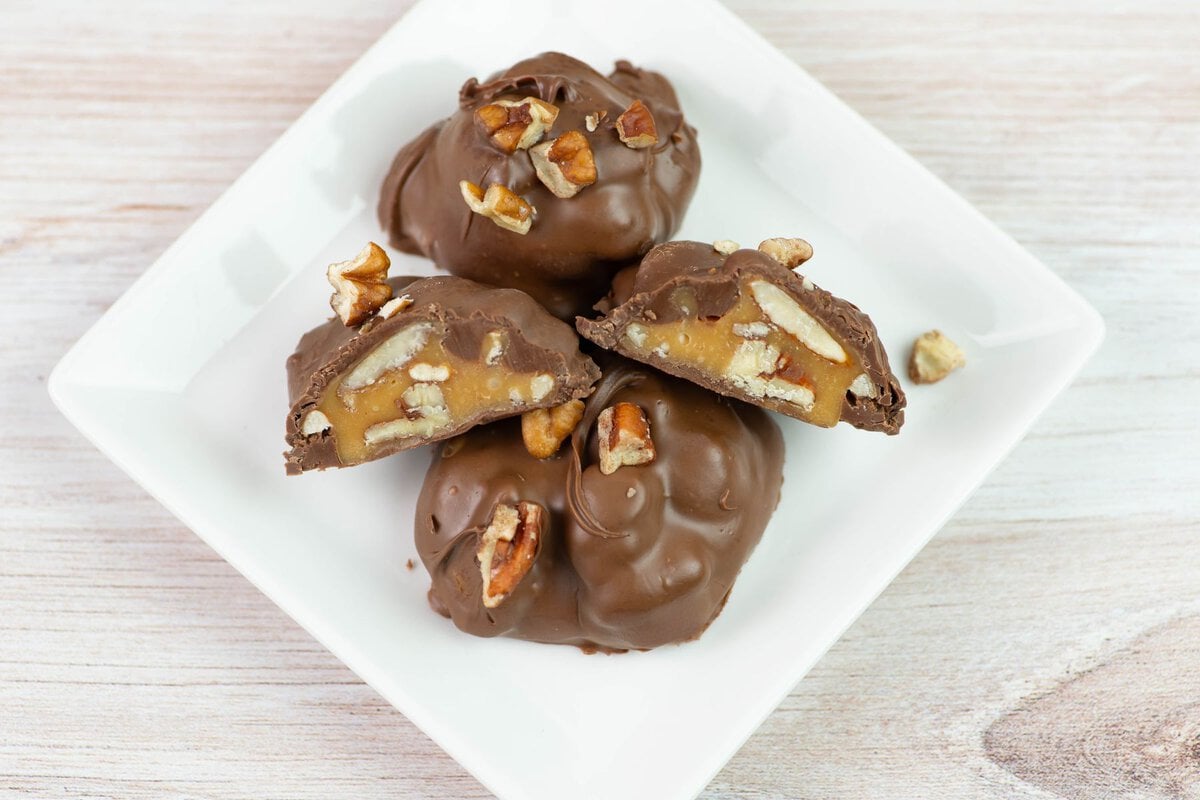 whole and cut Pecan cluster candies on a small plate.