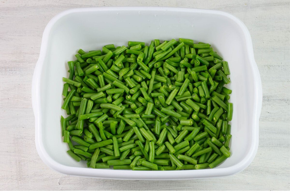 Trimmed and cut string beans in a white plastic tub.