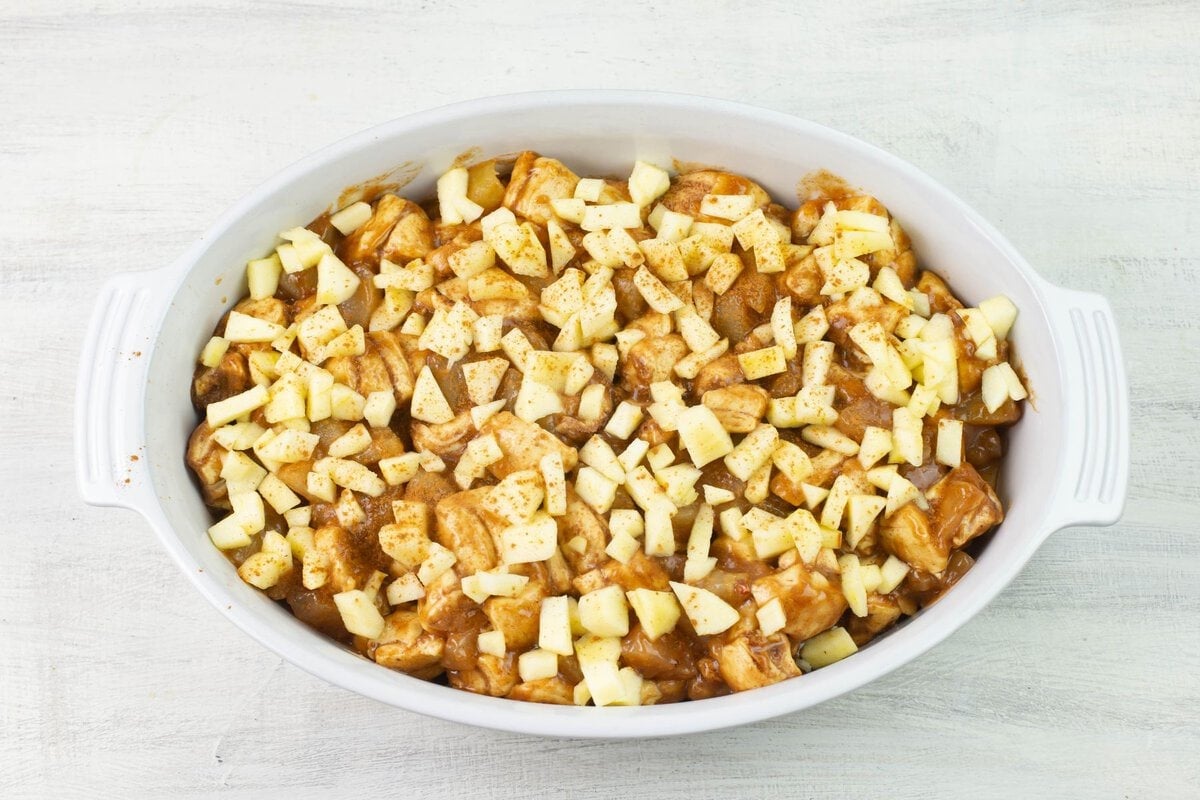 Topping the baked fritter breakfast casserole with apples and cinnamon.