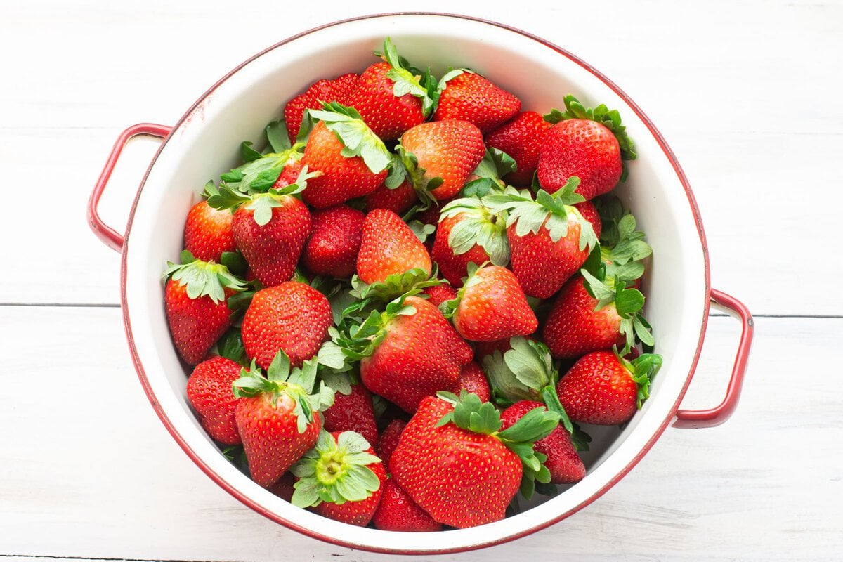 A colander filled with washed fresh strawberries.